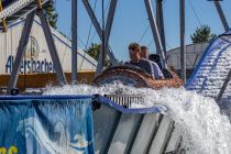 Wildwasser (Bergmann-Dölle) - Wildwasserbahn - Volksfest - Bilder 2023 - In einem der Boote im Holzstamm-Stil können vier Personen hintereinander Platz nehmen. • © ummet-eck.de / kirmesecke.de